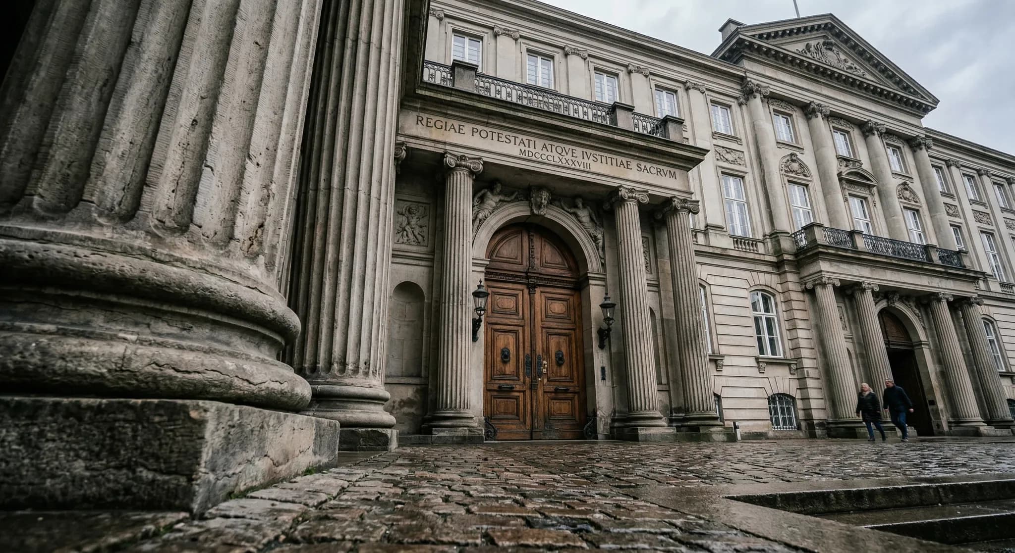 A low-angle photorealistic shot of a neoclassical government building with grand stone columns and a large wooden entrance. The scene is set under a soft, overcast sky typical of Northern Europe. Shal