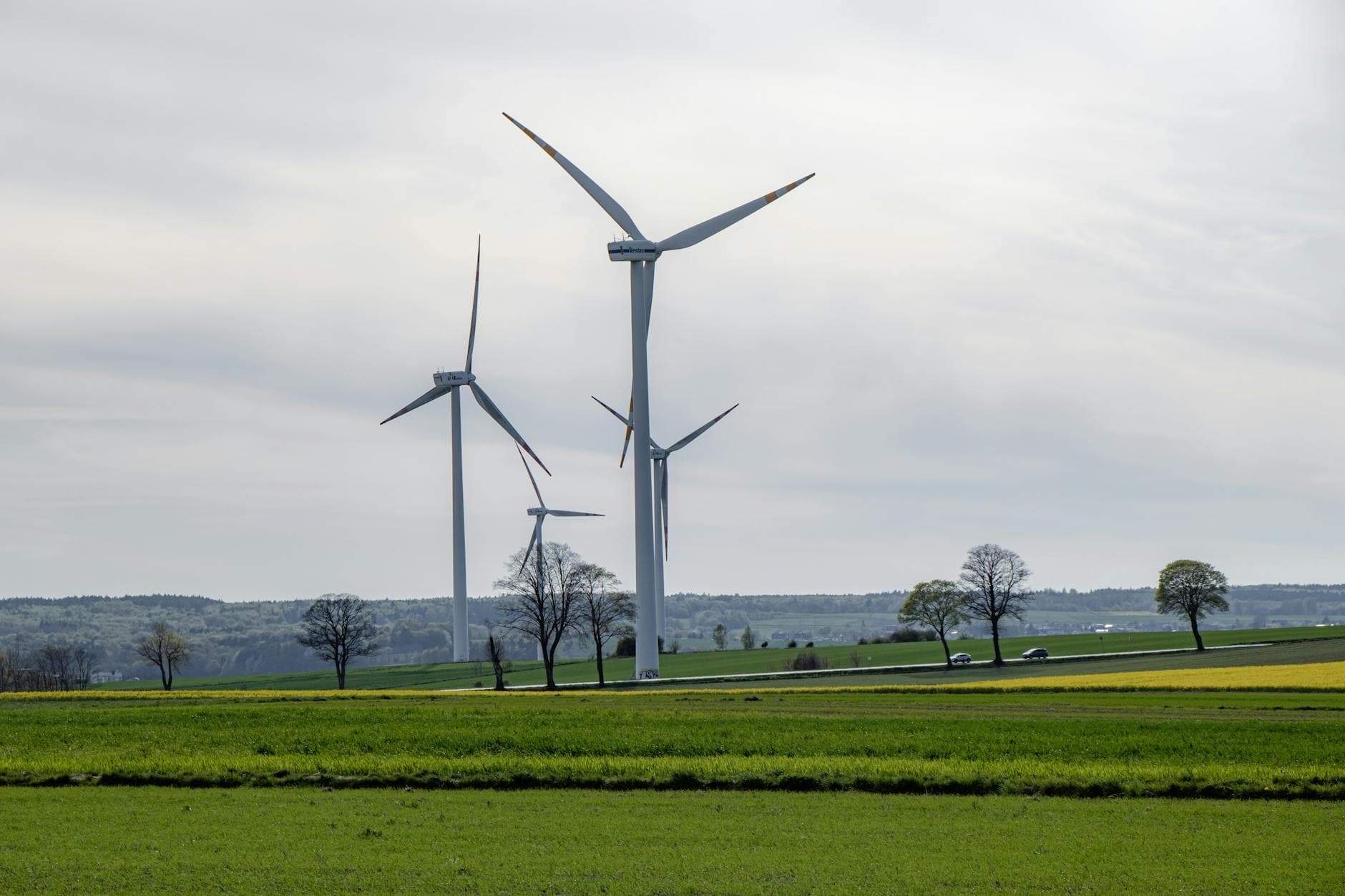 Scenic view of wind turbines in a green field, symbolizing renewable energy.