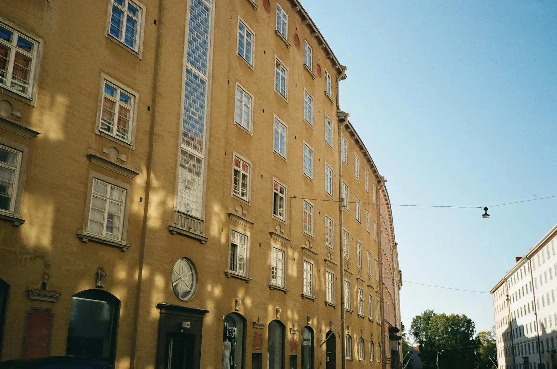 Exterior view of a yellow urban apartment building with classic architecture.