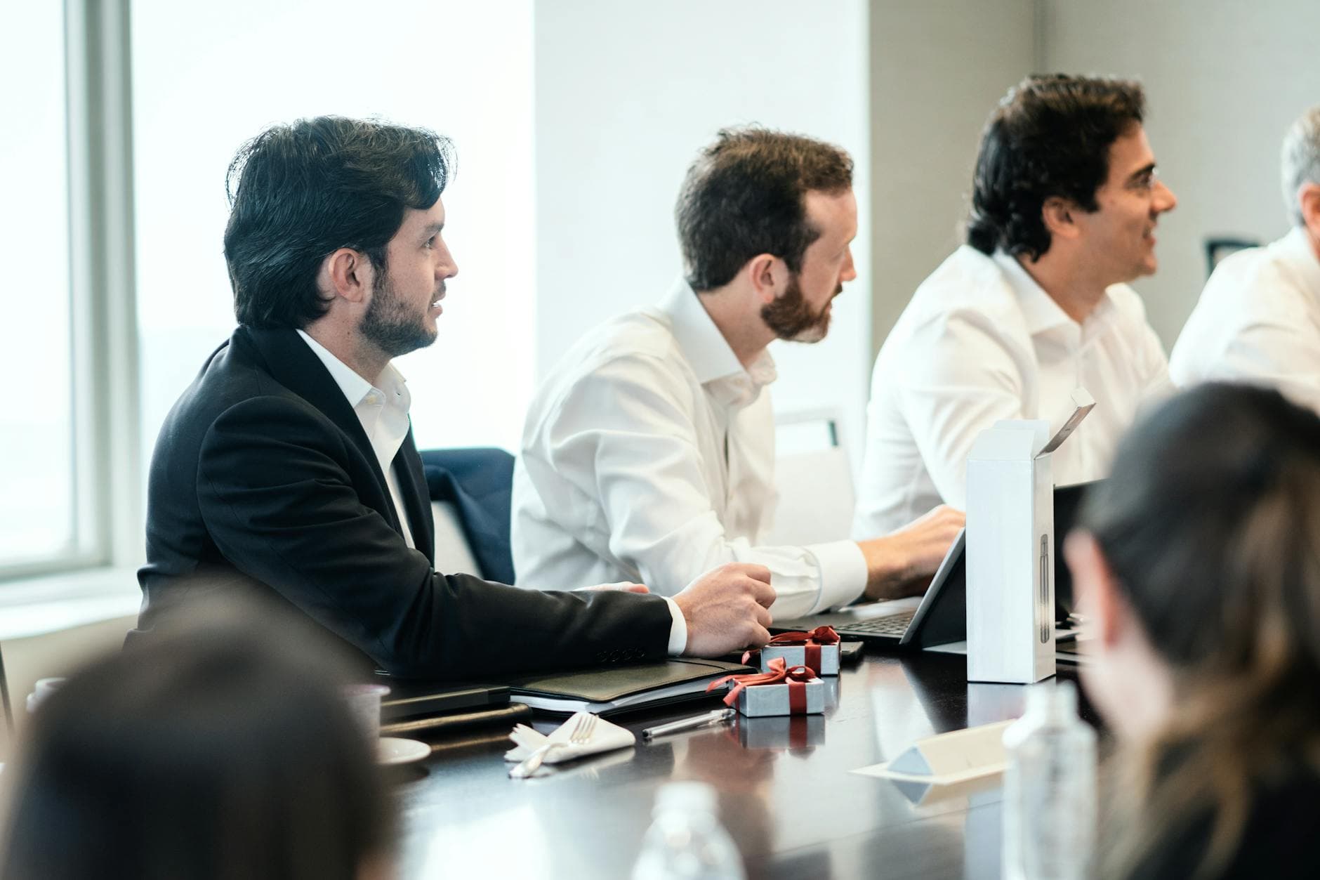 People in formal attire engaging in a collaborative business meeting.