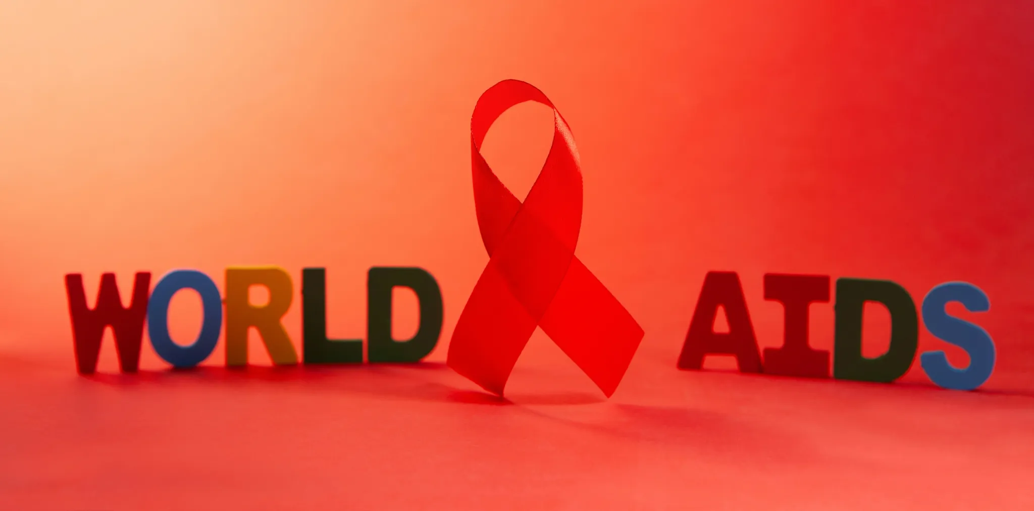 Red ribbon and letters spelling world aids