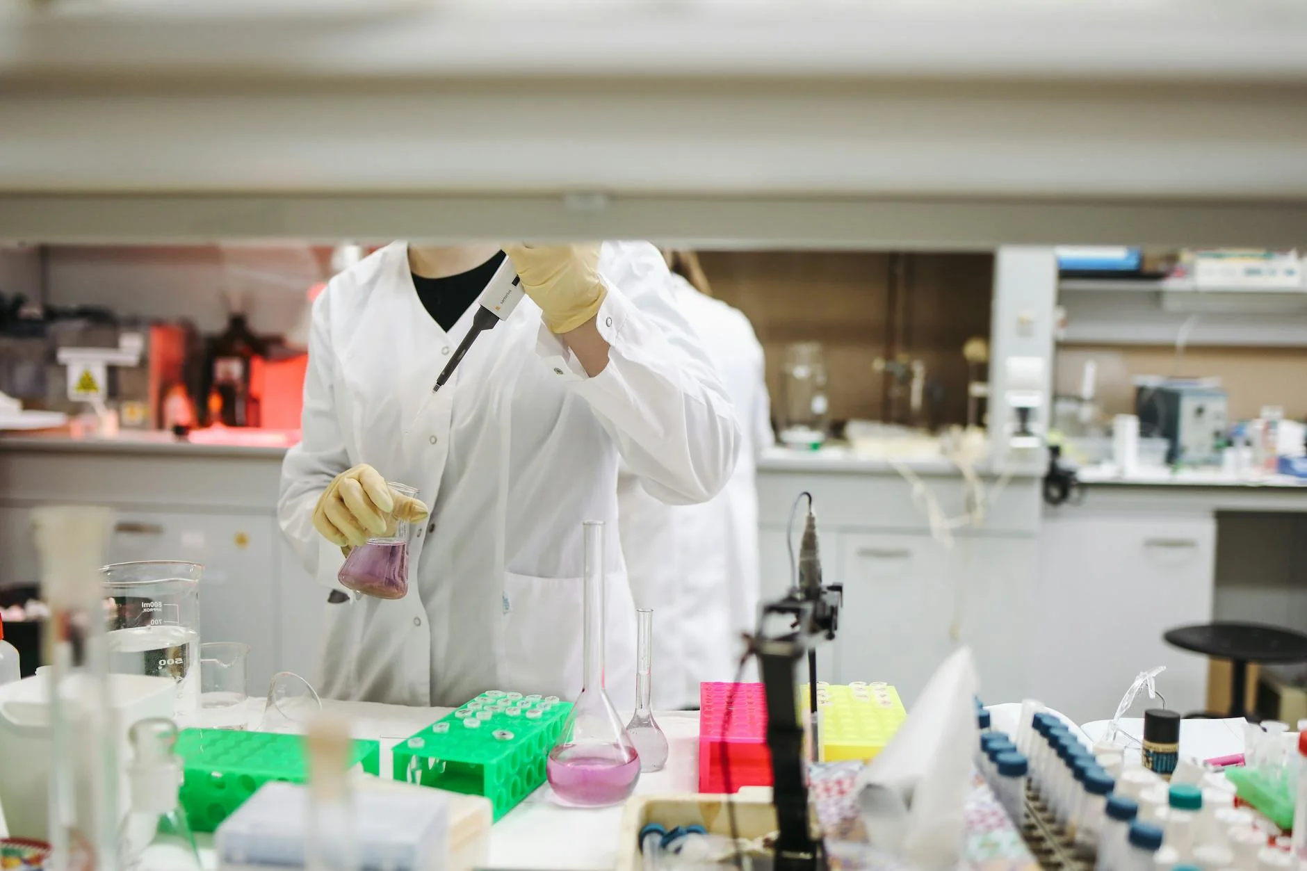 Scientist in a lab coat handling samples for scientific research in a modern laboratory setting.