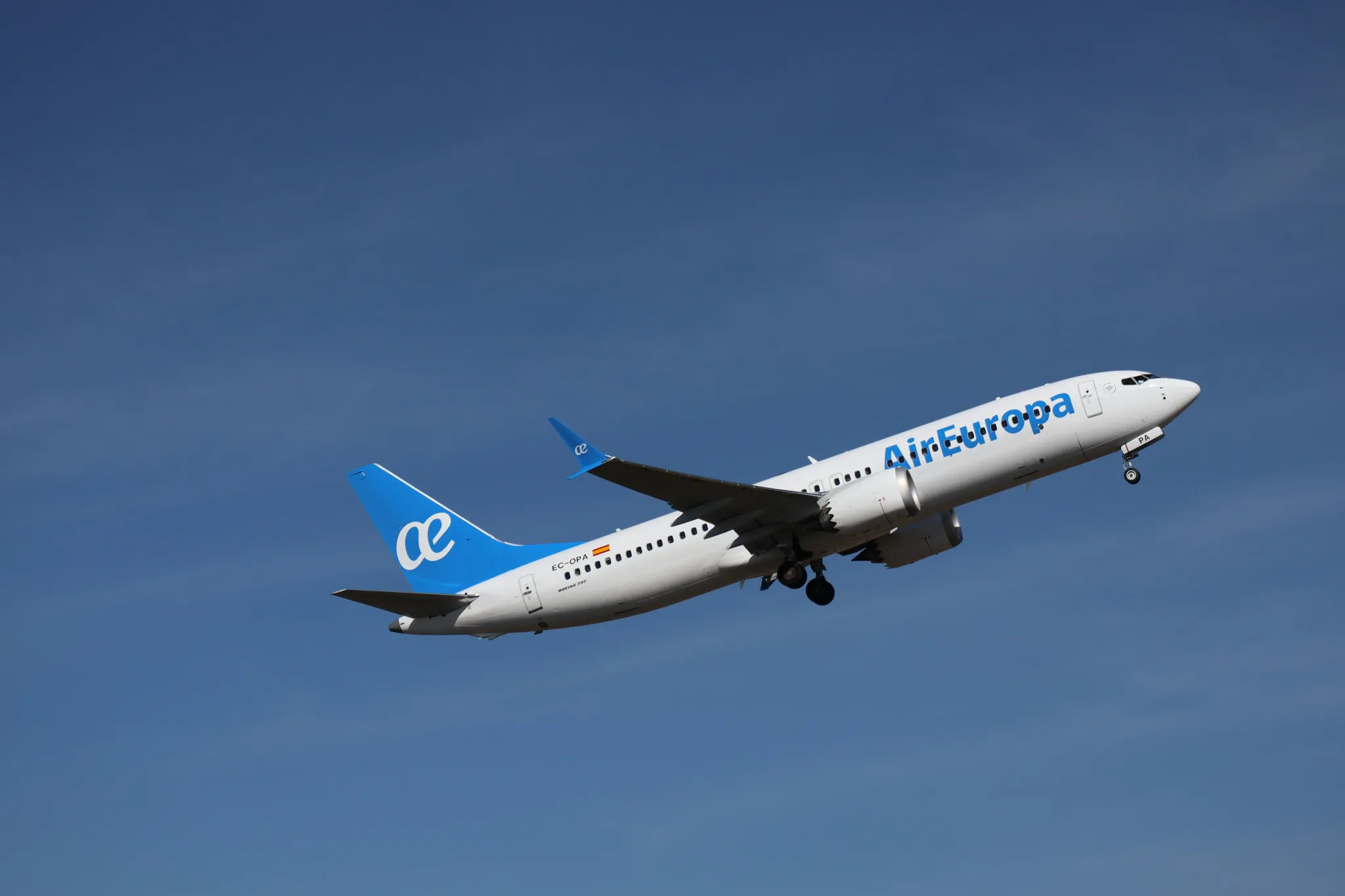 An air europa airplane ascends into a clear blue sky.