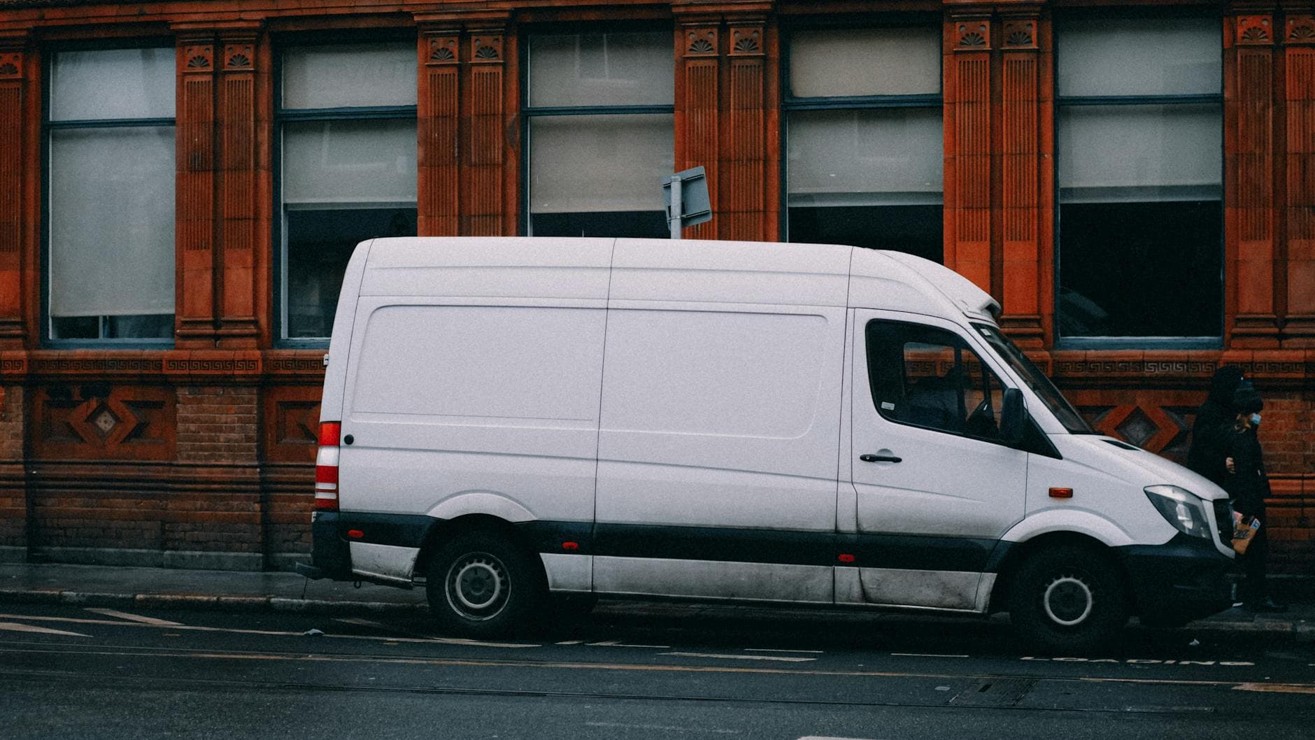 A white van parked alongside a red brick building in Dublin, Ireland.