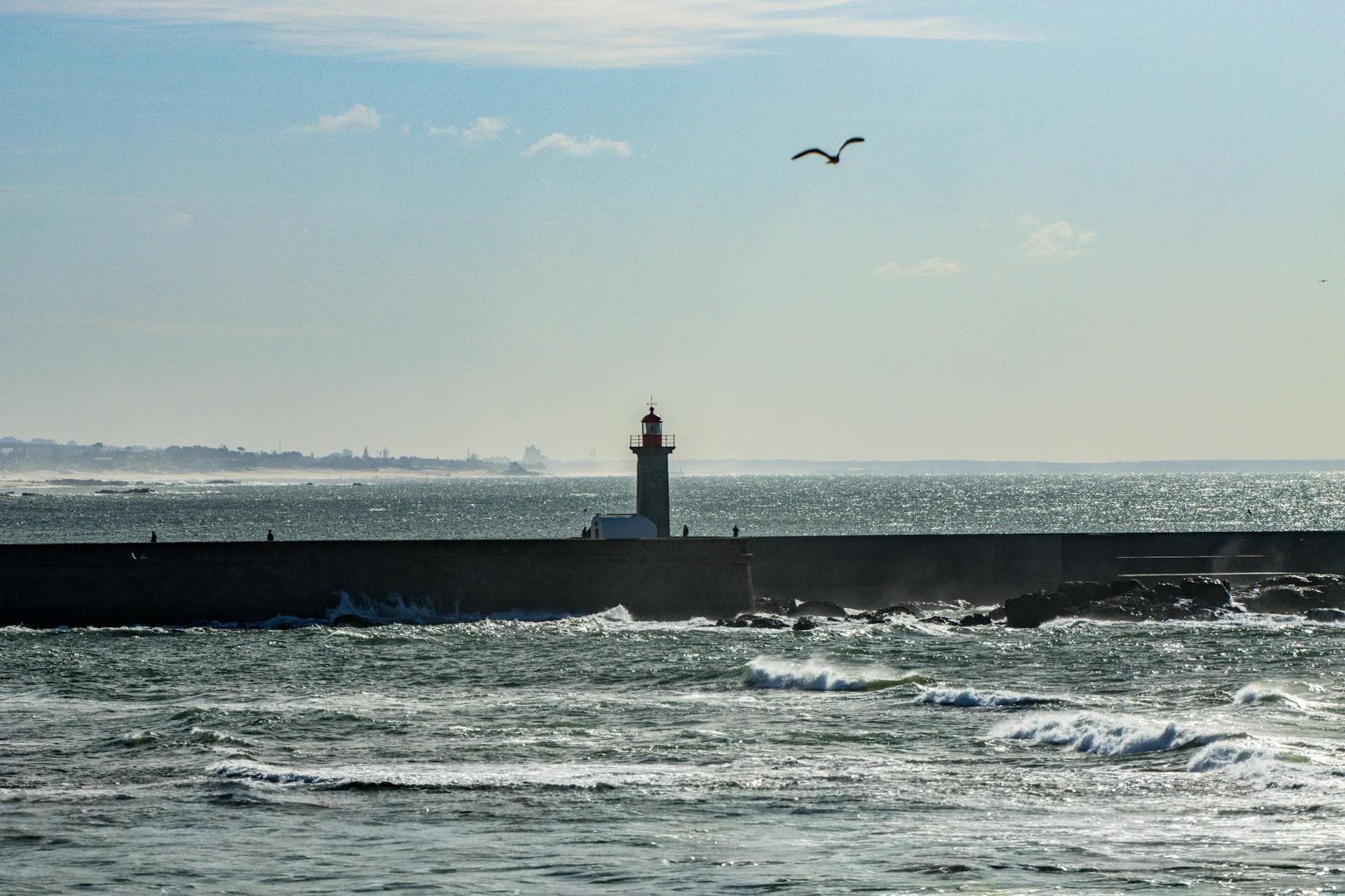 Silhouette of a lighthouse at Matosinhos coastline, Portugal during a sunny day.