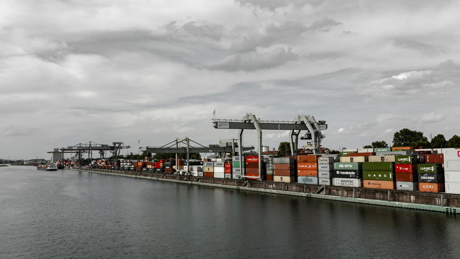 Aerial view of Mannheim's bustling cargo port displaying numerous shipping containers and cranes.