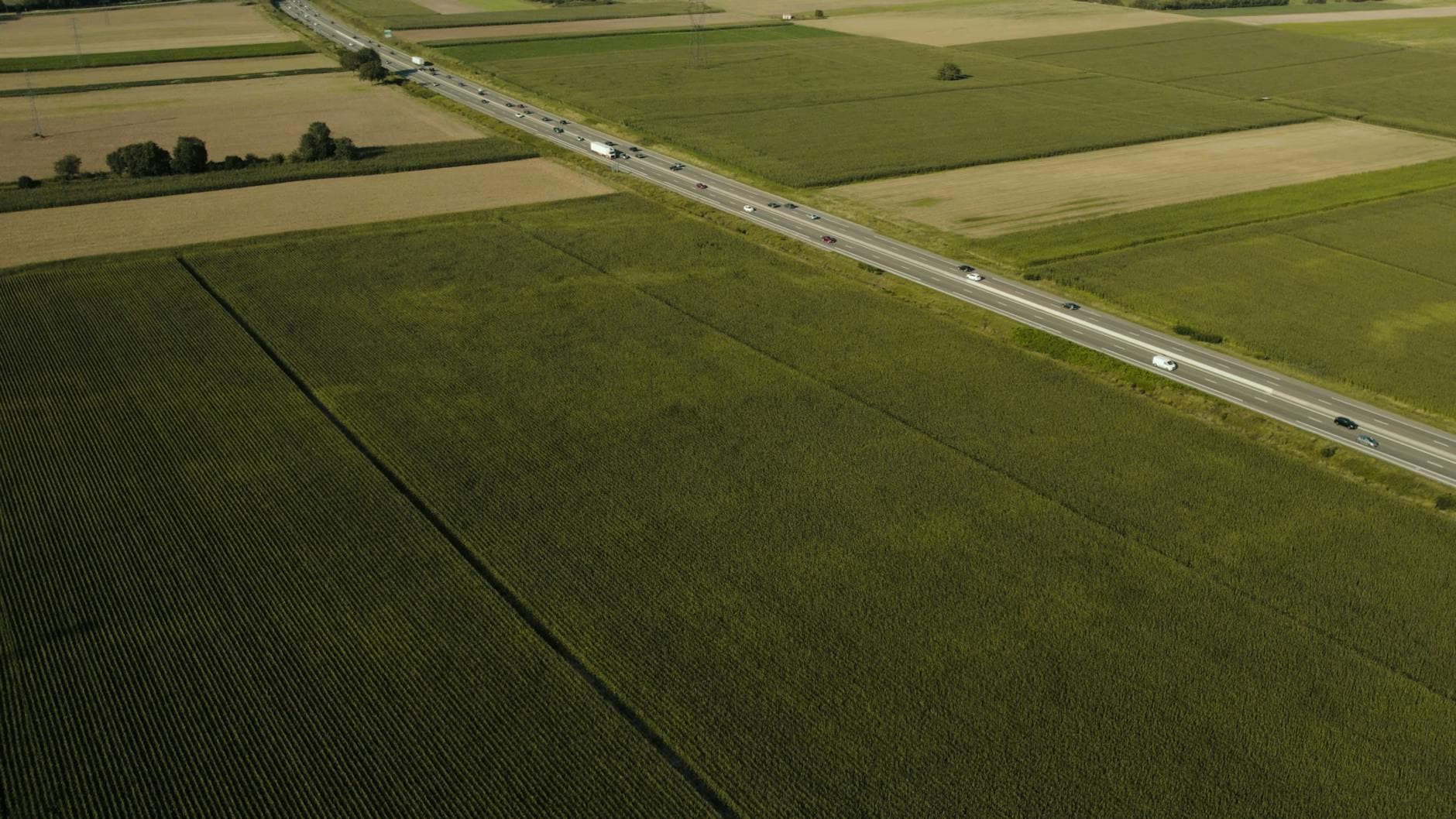Drone shot of a highway cutting through fields in Sélestat, France.