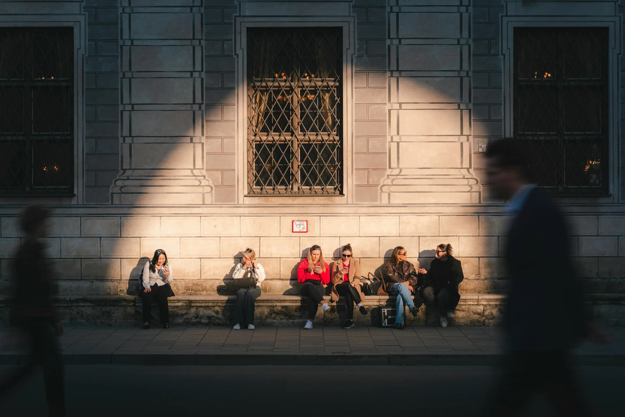 People sitting on a bench in sunlight