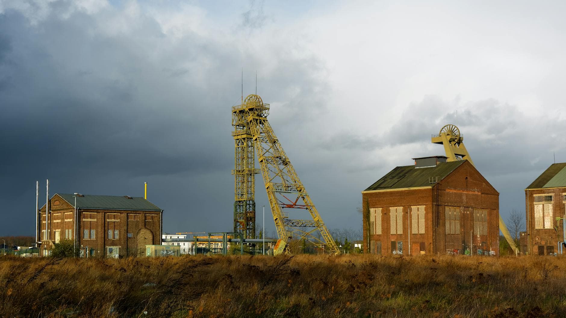 Old mining structures at an industrial site in Velbert, Germany, under a dramatic sky.