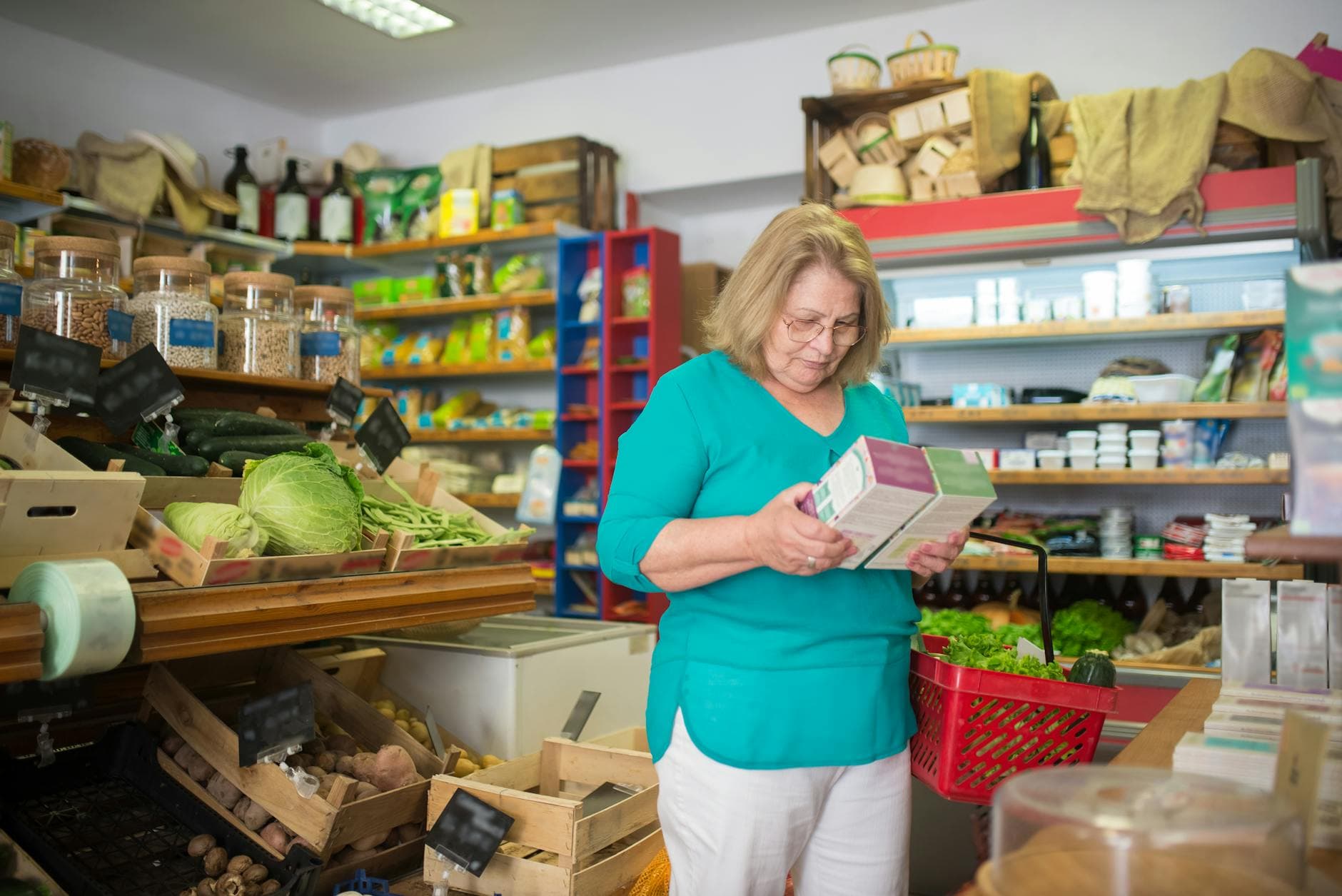 An elderly woman examines a product in a grocery store in Portugal.
