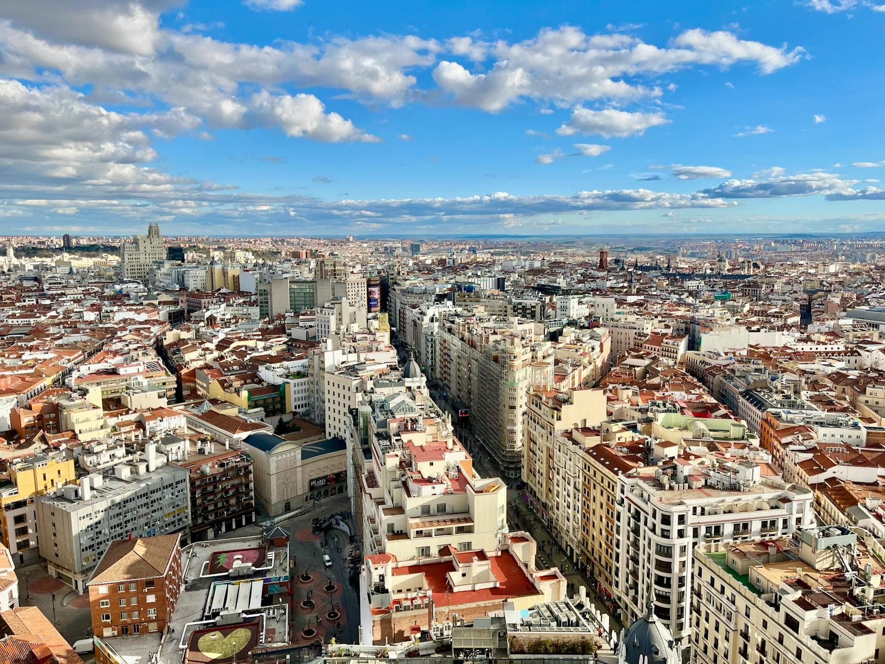 Stunning aerial view of Madrid's skyline with vibrant cityscape under a blue sky.