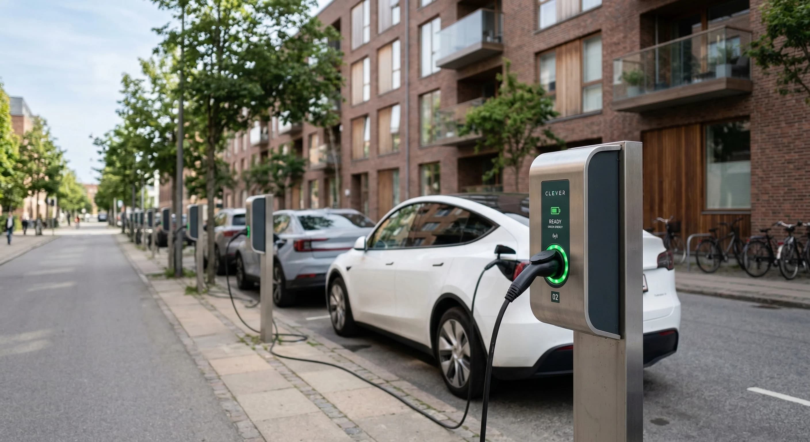 A modern Scandinavian residential street with a row of sleek electric vehicle charging stations installed along the sidewalk next to a contemporary brick apartment building. The scene is captured in s